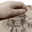 a close up of a person 's hand holding a piece of paper with a drawing of a face on it .