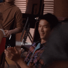 a man in a plaid shirt is sitting next to a woman