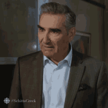 a man in a suit is making a funny face and saying what
