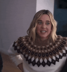a woman is wearing a sweater with a pattern on it