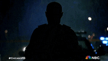 a silhouette of a police officer in the rain with #chicagopd