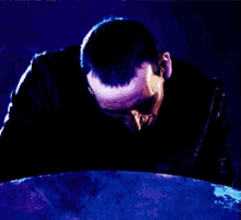 a man with a surprised look on his face stands in front of a blue object