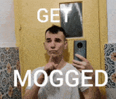 a man taking a picture of himself with the words get mogged below him