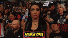 a woman named roxanne perez stands in front of a crowd of people