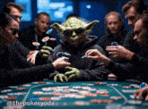 a group of people are playing poker and one of them is dressed like yoda