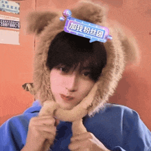 a young man wearing a teddy bear hat with a sign on his head