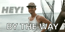 a man in a tank top is standing on a boat in the ocean .