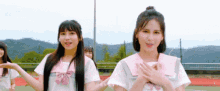 a group of young girls are standing next to each other on a track and field .