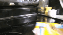 a person cleaning a stove top with a bag of bleach