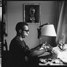a black and white photo of a man sitting at a table