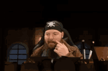 a man with a beard is wearing a pirate hat