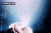 a close up of a person 's face in a dark room with a blue light behind them .