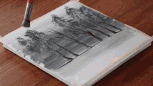 a black and white painting of trees is being painted with a brush