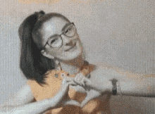 a woman is making a heart shape with her hands .