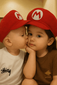 two children wearing mario hats kissing each other