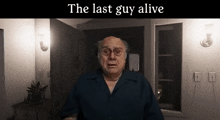 a man in a blue shirt is standing in a dark room with the words the last guy alive below him