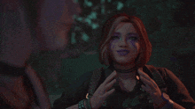 a woman with purple paint on her face is reaching out