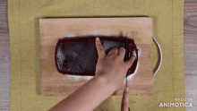 a person is cutting a loaf of bread on a wooden cutting board made by animatica