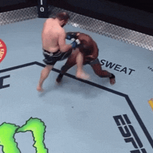 two men are fighting in a boxing ring with the words sweat written on the floor