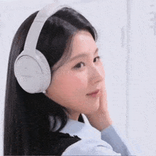 a woman wearing white bose headphones looks to her left