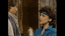 a man and a woman are standing next to each other and talking .