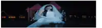 a woman in a wedding dress and veil is standing in front of a fire .