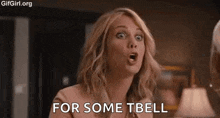 a woman is making a funny face and saying `` for some tbell '' while talking to another woman .