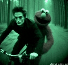 a man riding a bike with elmo on the back