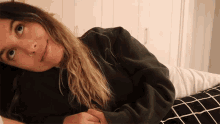 a woman with a nose ring is laying on her stomach