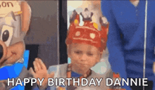 a little boy wearing a crown is standing in front of a chipotle mascot and says `` happy birthday dannie '' .