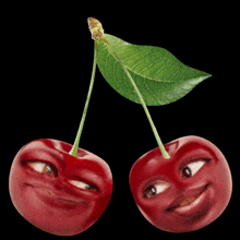 two cherries with faces on them and a heart on top