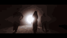 a group of people standing in the dark with a light behind them