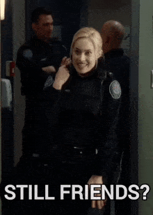 a woman in a police uniform is standing next to a sign that says still friends ?