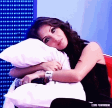a woman holding a white pillow with edits portirroni on the bottom right
