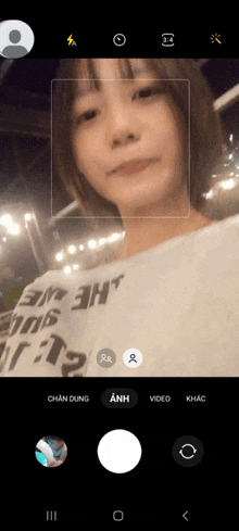 a woman taking a selfie with a white shirt that says 3m 3ht on it