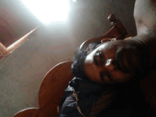 a man is laying on a wooden bed with his head on the headboard