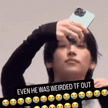 a picture of a man holding a cellphone with a caption that says " even he was weirded tf out "