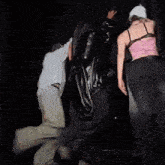 three people are dancing in a dark room .