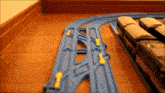 a toy train is going down a track with a yellow light on it