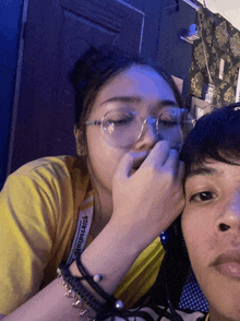 a woman wearing glasses and a yellow shirt with the word ultramnt on it