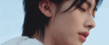 a close up of a person 's face with their eyes closed and a piercing in their ear .