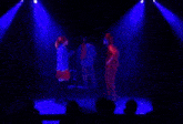 a group of people on stage with blue lights behind them