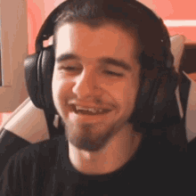 a man with a beard wearing headphones and smiling
