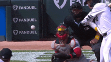 a baseball player swings at a ball in front of a fanduel banner