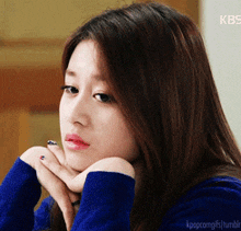 a close up of a woman 's face with a kbs logo behind her