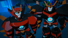 two transformers are standing next to each other and one of them has a transformer logo on his chest