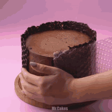 a person wrapping a chocolate cake with bubble wrap