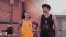 a man and a woman are standing next to each other and the woman is wearing a yellow tank top that says ipe