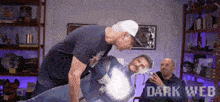 a man is holding a cardboard cutout of a man in a superhero costume while another man watches .