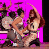 a woman singing into a microphone while wearing a shirt that says " at "
